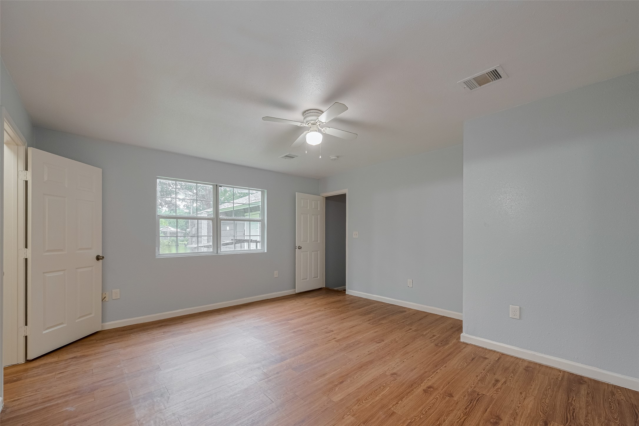 4906 Larkspur Street Houston, TX 77033 - Photo 11 of 14 an empty room with wooden floor and windows