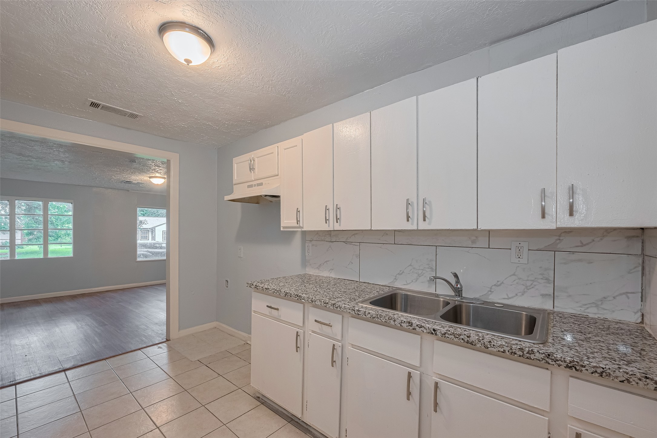 4906 Larkspur Street Houston, TX 77033 - Photo 6 of 14 a kitchen with granite countertop white cabinets and sink