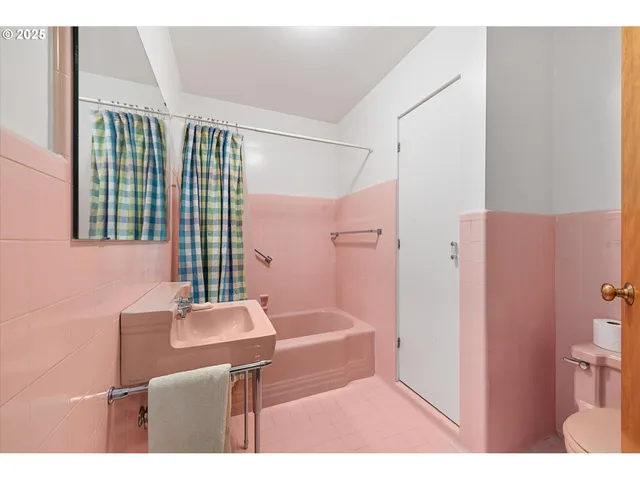 a living room with stainless steel appliances wooden floors and white walls