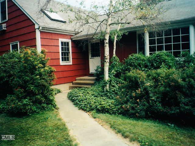 182 Catalpa Road Wilton, CT 06897 - Photo 1 of 1 a view of a brick house with a large windows and flower plants