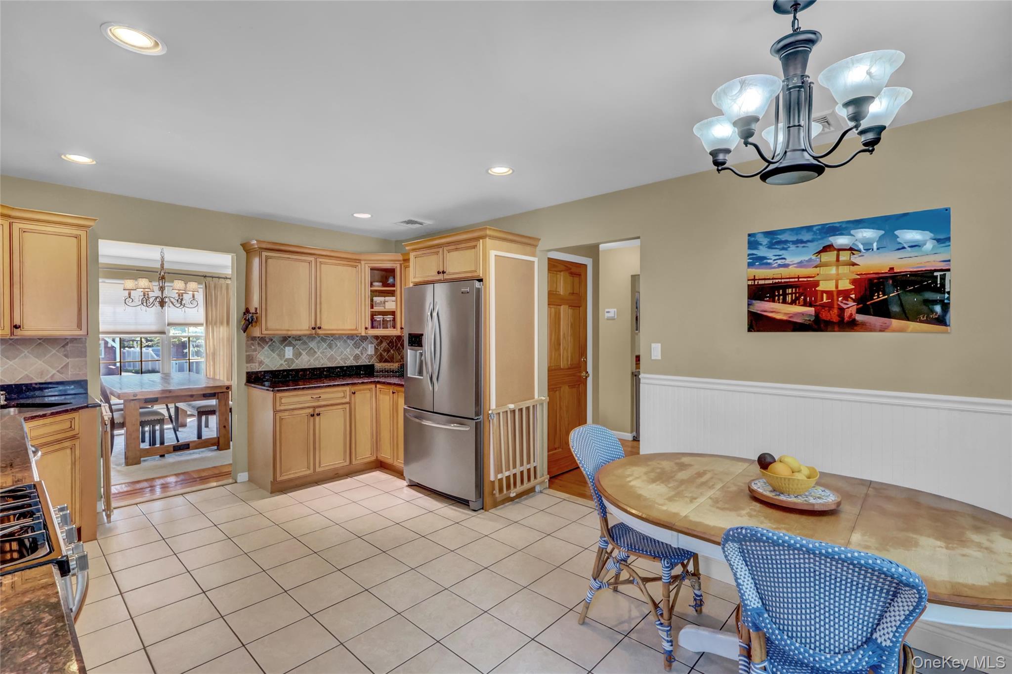18 Hampton Road Lynbrook, NY 11563 - Photo 18 of 37 a kitchen with stainless steel appliances granite countertop a sink a stove a dining table and chairs