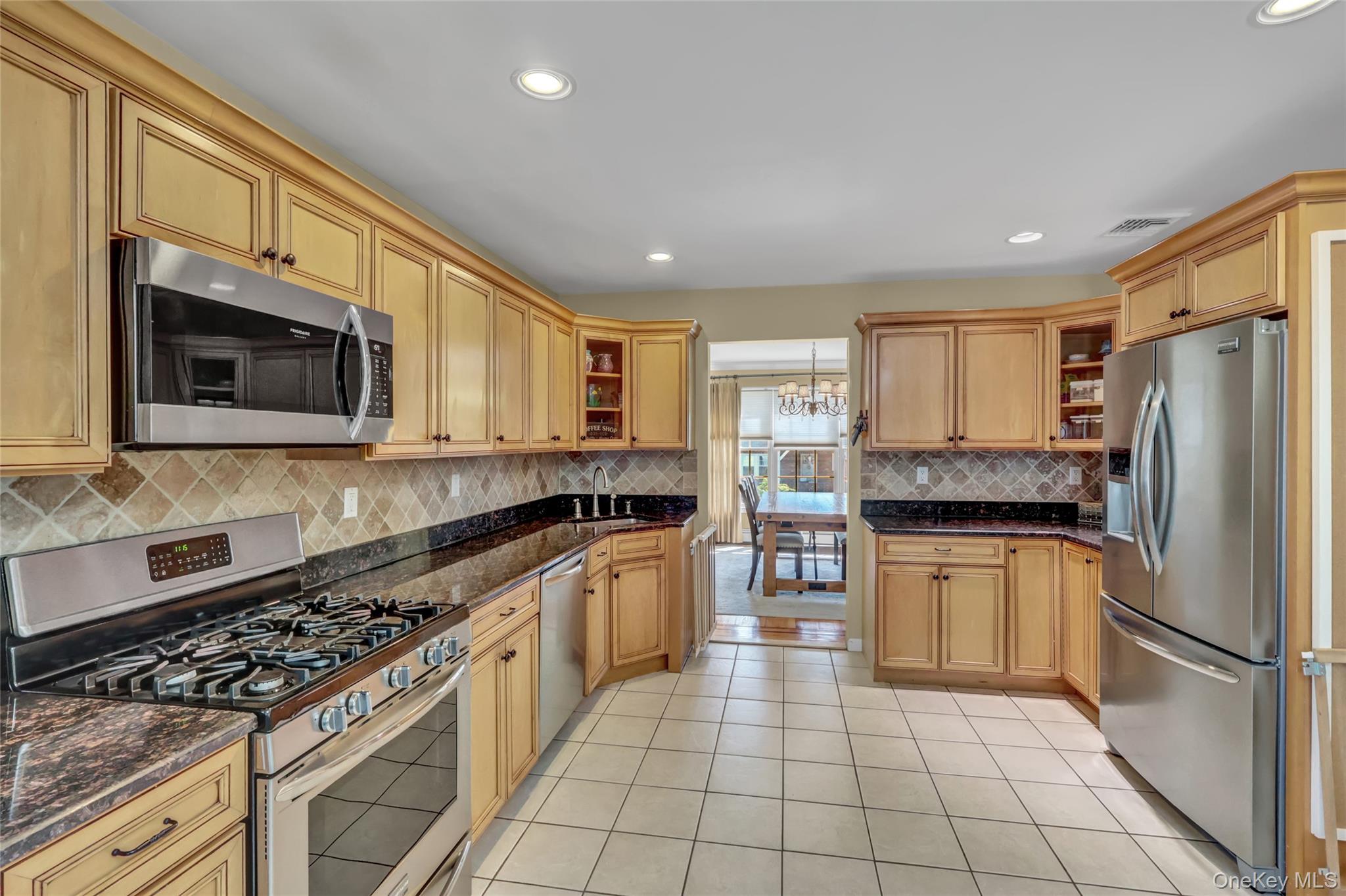 18 Hampton Road Lynbrook, NY 11563 - Photo 19 of 37 a kitchen with stainless steel appliances granite countertop a stove top oven a sink dishwasher a refrigerator and a microwave
