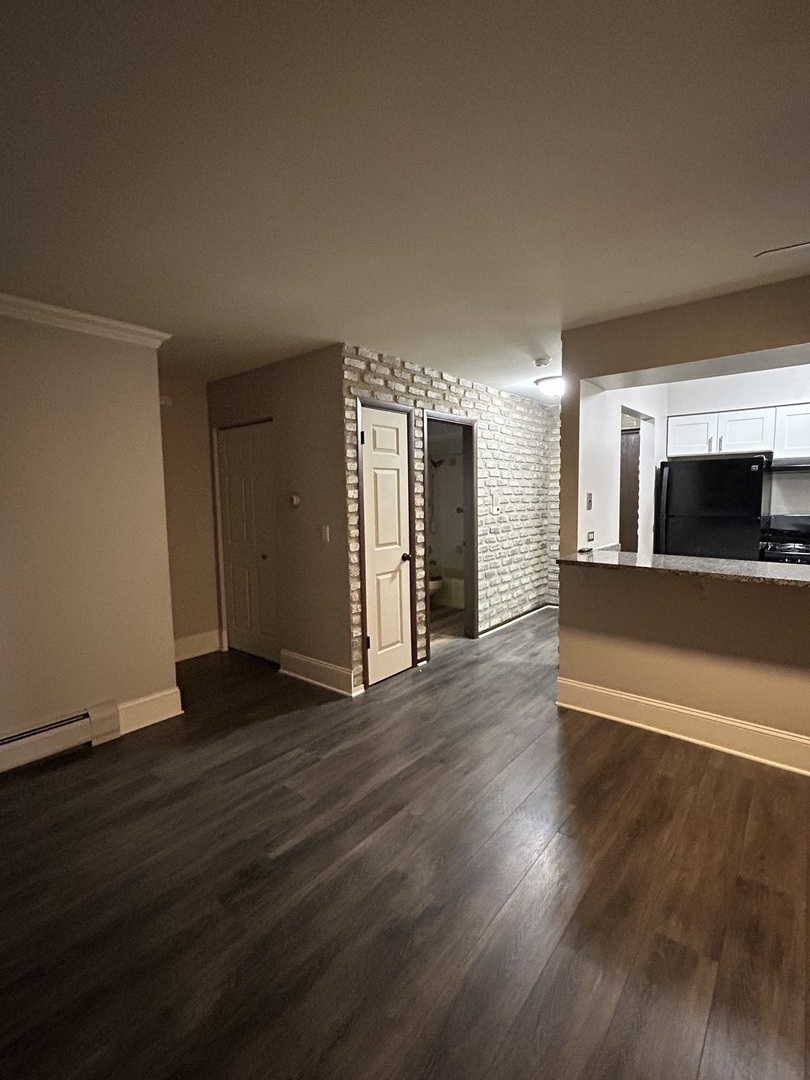 235 North Mill Road, Unit 114B Addison, IL 60101 - Photo 9 of 28 a view of a big room with wooden floor and a fireplace