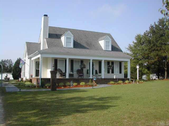 1035 Clayton Road Benson, NC 27504 - Photo 1 of 7 a front view of a house with a garden and trees