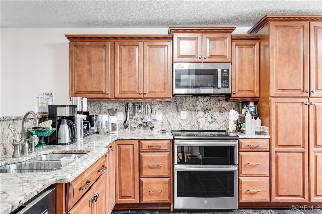3003 Chartwood Drive Sandston, VA 23150 - Photo 4 of 29 a kitchen with granite countertop a stove a sink and a microwave