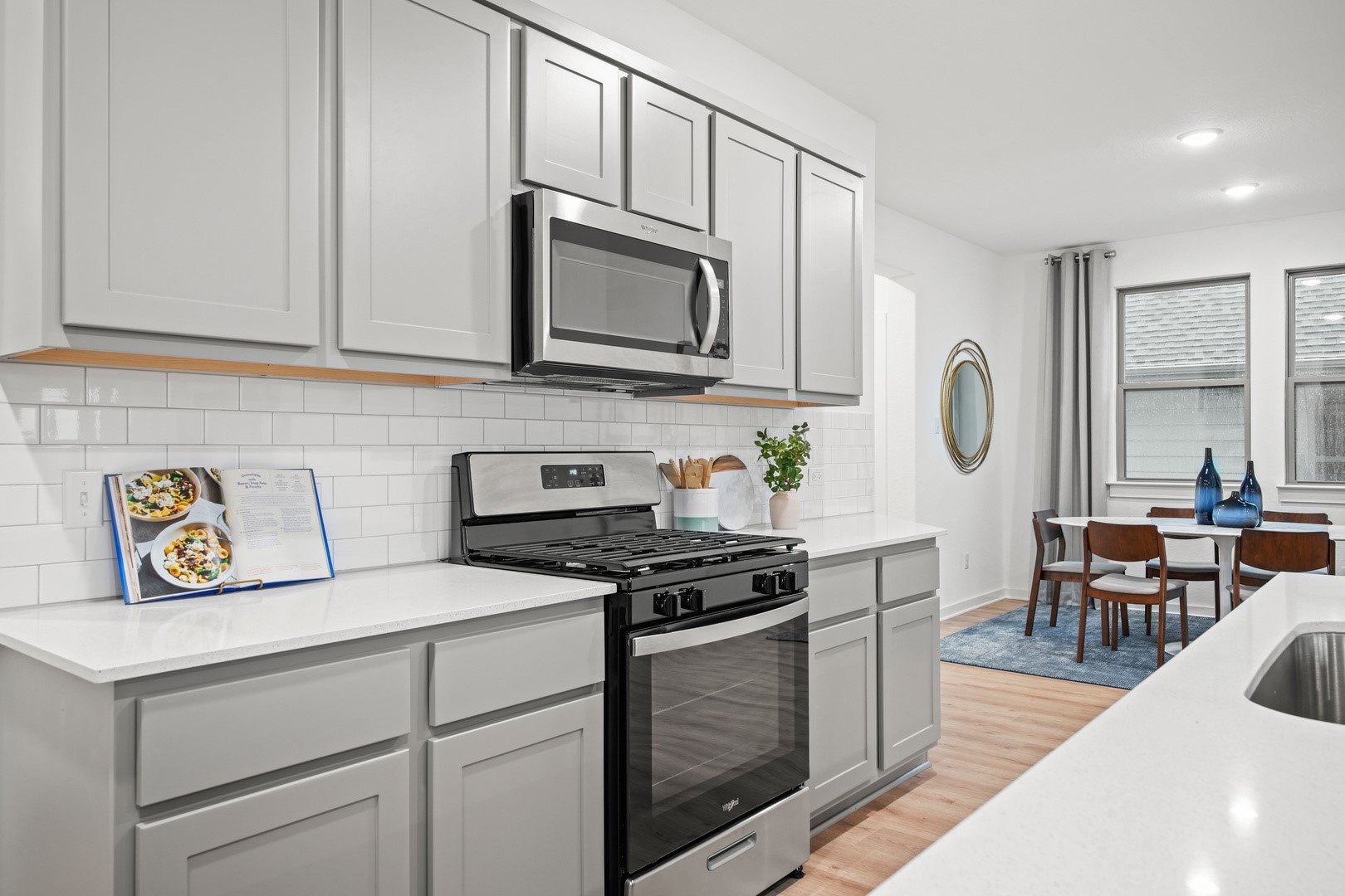 194 Hornet Street Elgin, TX 78621 - Photo 5 of 40 a kitchen with stainless steel appliances granite countertop a stove a sink and a microwave