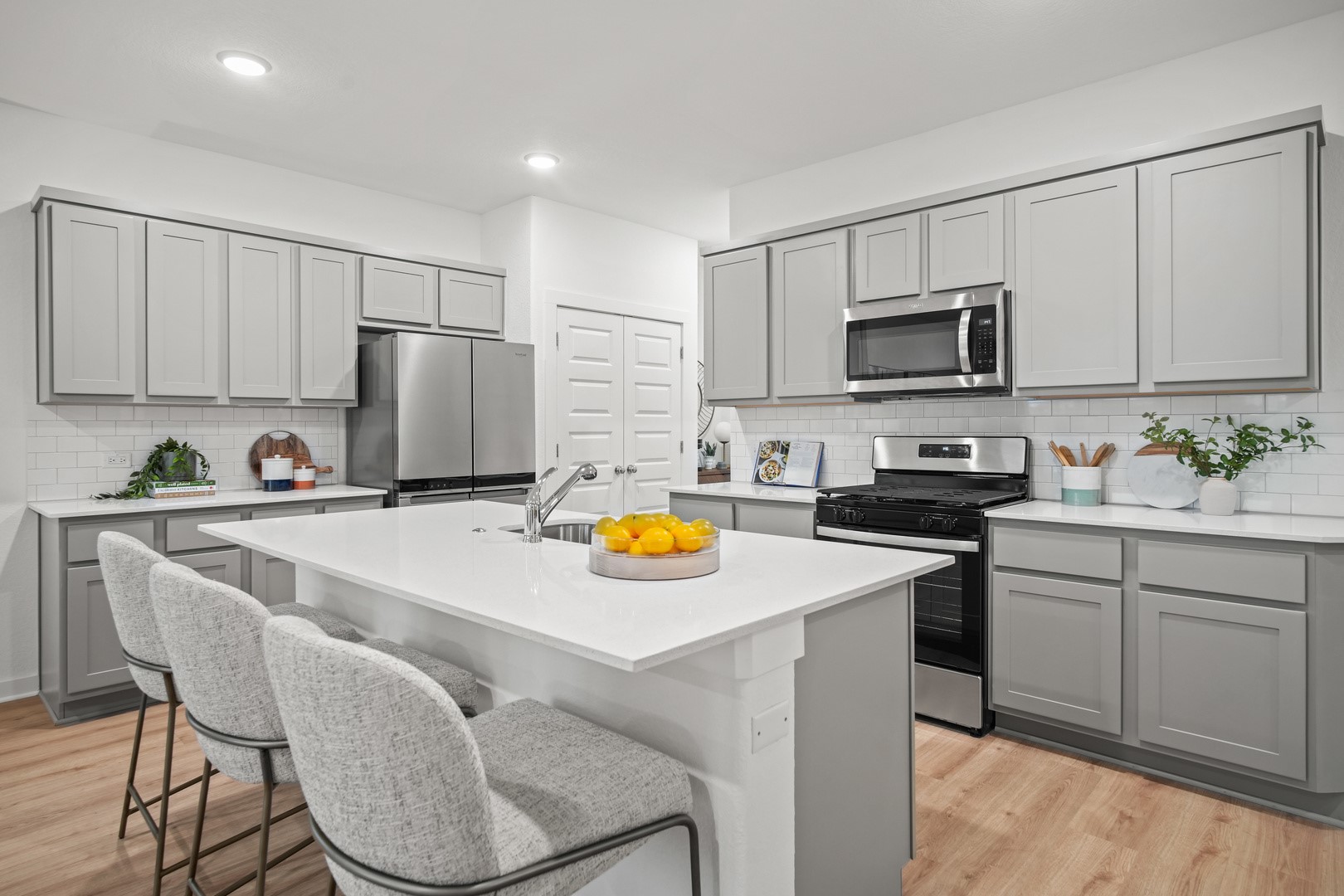 194 Hornet Street Elgin, TX 78621 - Photo 6 of 40 a kitchen with stainless steel appliances a stove a sink a refrigerator a microwave and cabinets