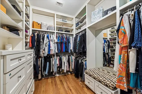 a view of walk in closet with clothes and shoes