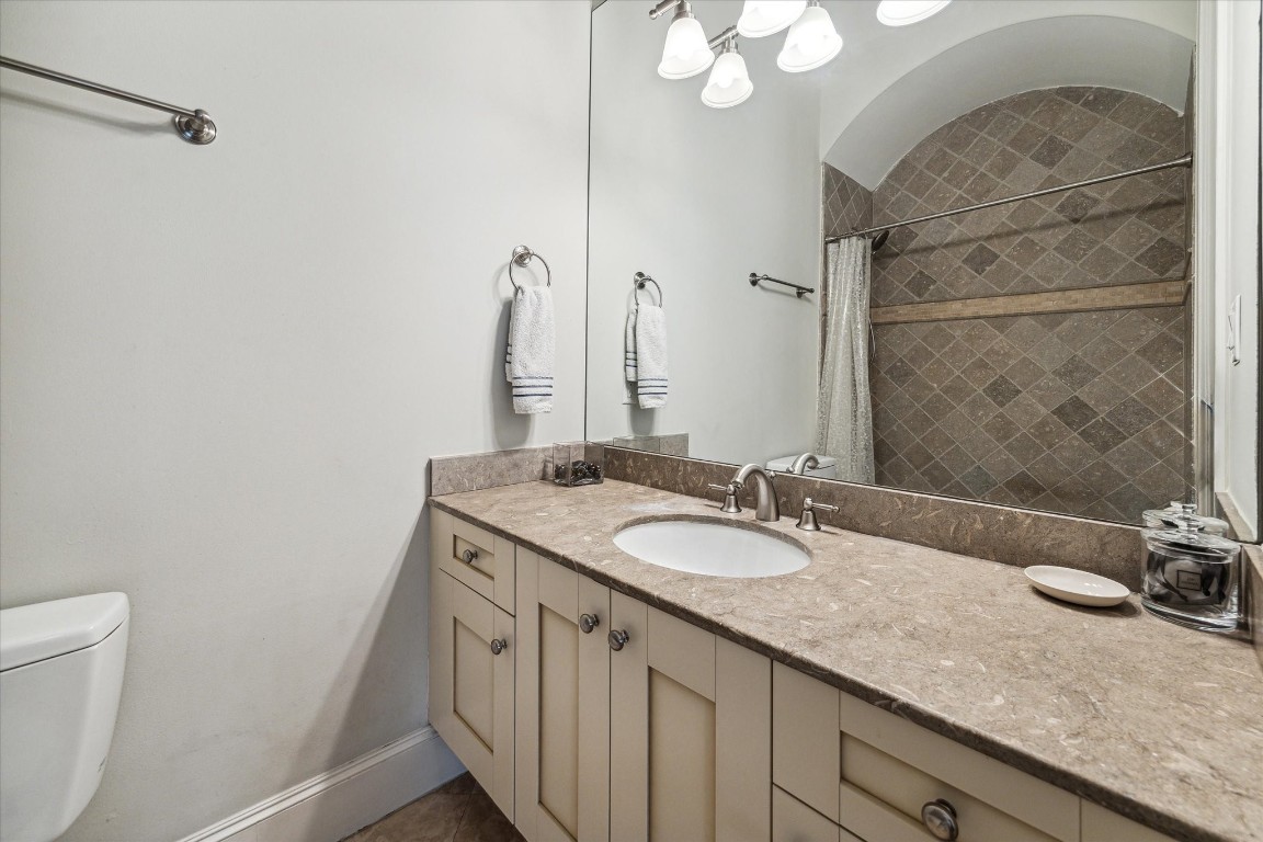 5213 Feagan Street, Unit A Houston, TX 77007 - Photo 29 of 47 a bathroom with a granite countertop sink a mirror and a toilet