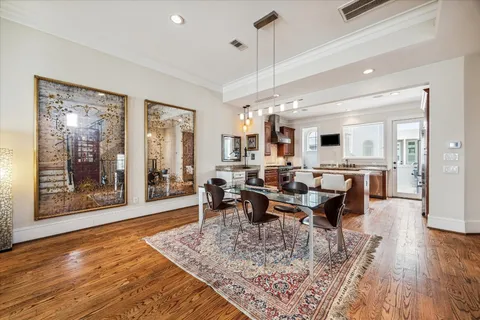 a view of a dining room and livingroom with furniture wooden floor a rug and a chandelier