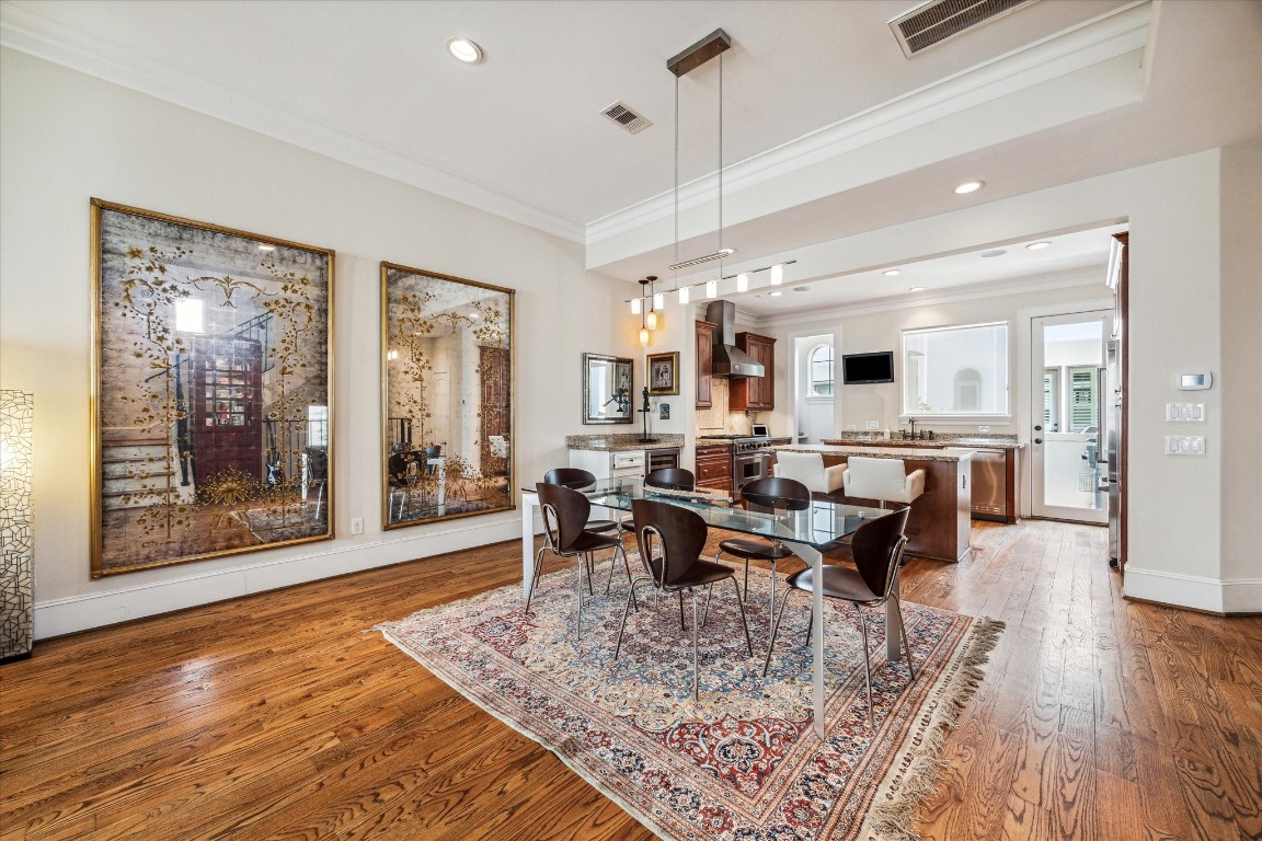 5213 Feagan Street, Unit A Houston, TX 77007 - Photo 9 of 47 a view of a dining room and livingroom with furniture wooden floor a rug and a chandelier
