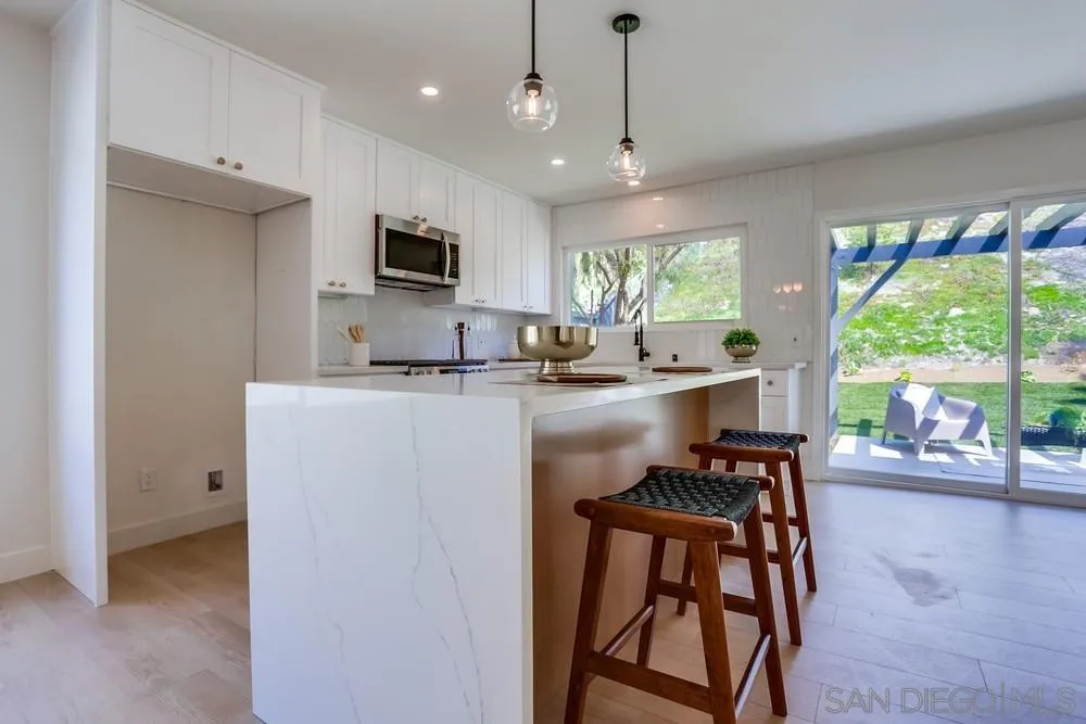 12701 McFeron Road Poway, CA 92064 - Photo 10 of 32 a kitchen with kitchen island a large counter top space appliances and a center island