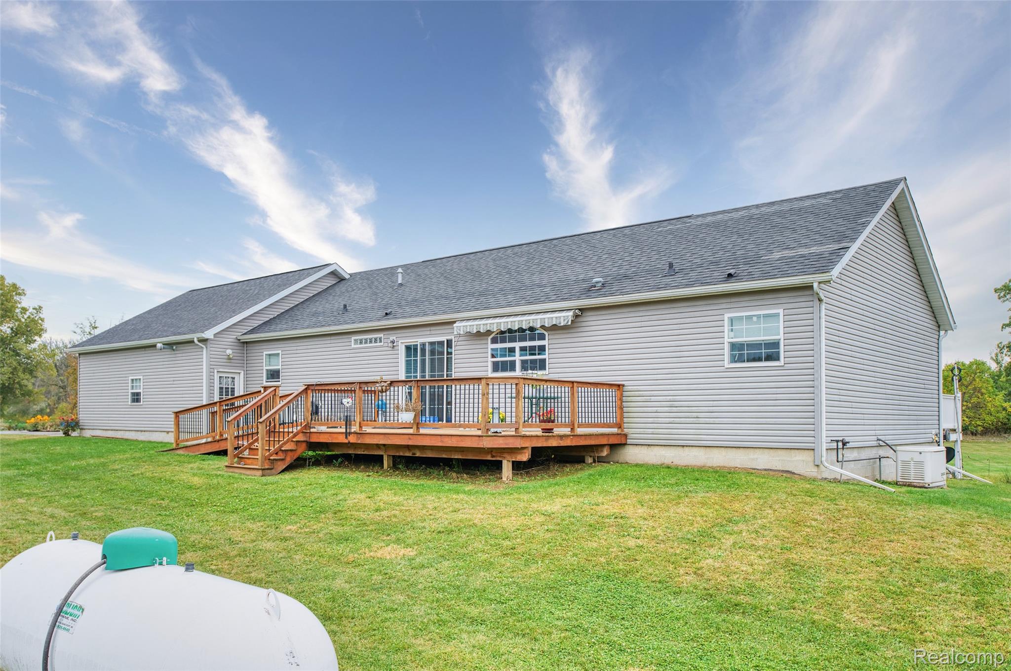 5601 West Lovejoy Road Byron, MI 48418 - Photo 27 of 40 Rear view of property featuring a deck, roof with shingles, and a yard