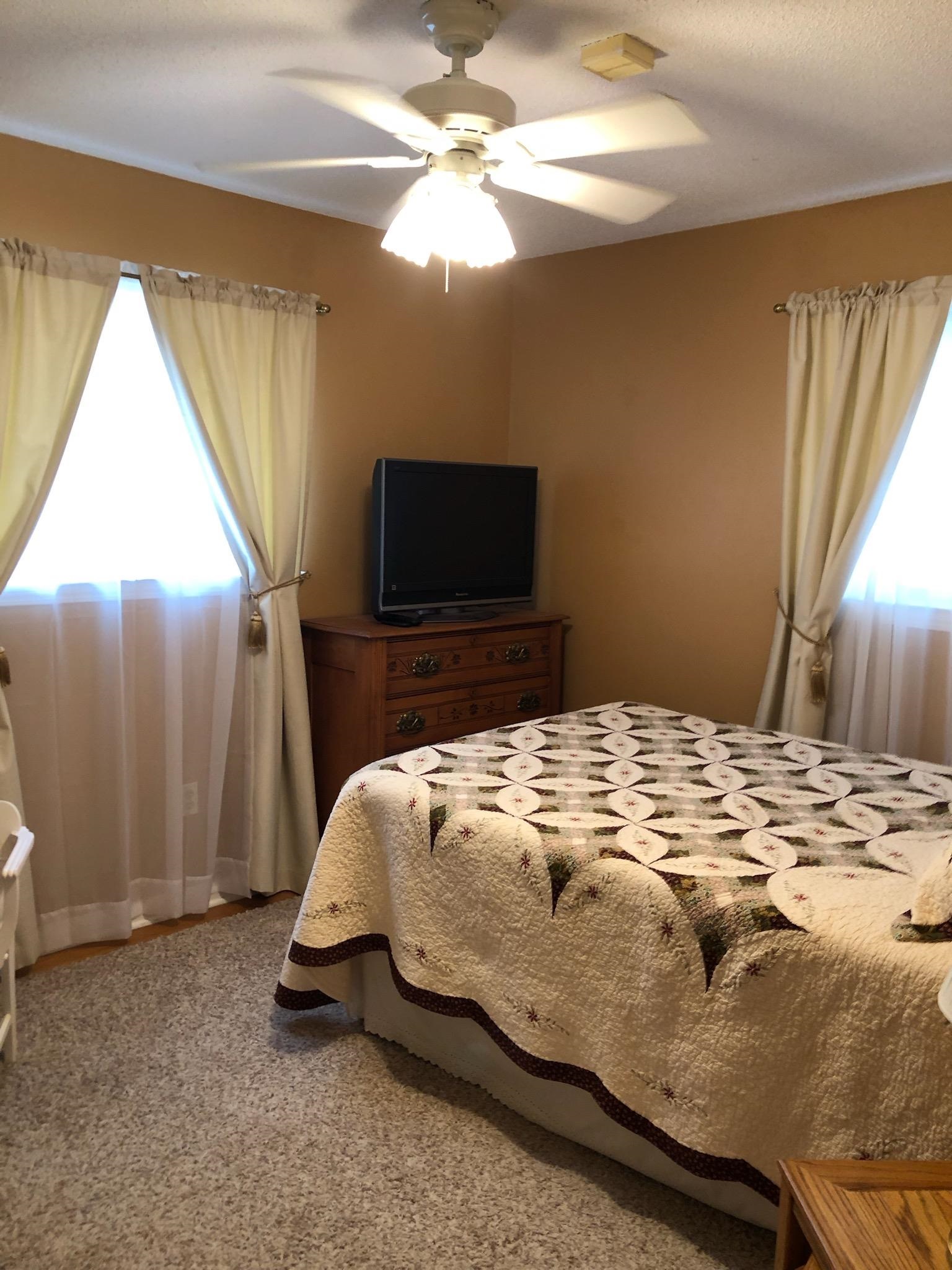 1424 Mullins Station Road Memphis, TN 38134 - Photo 18 of 40 a bedroom with a bed and a chandelier