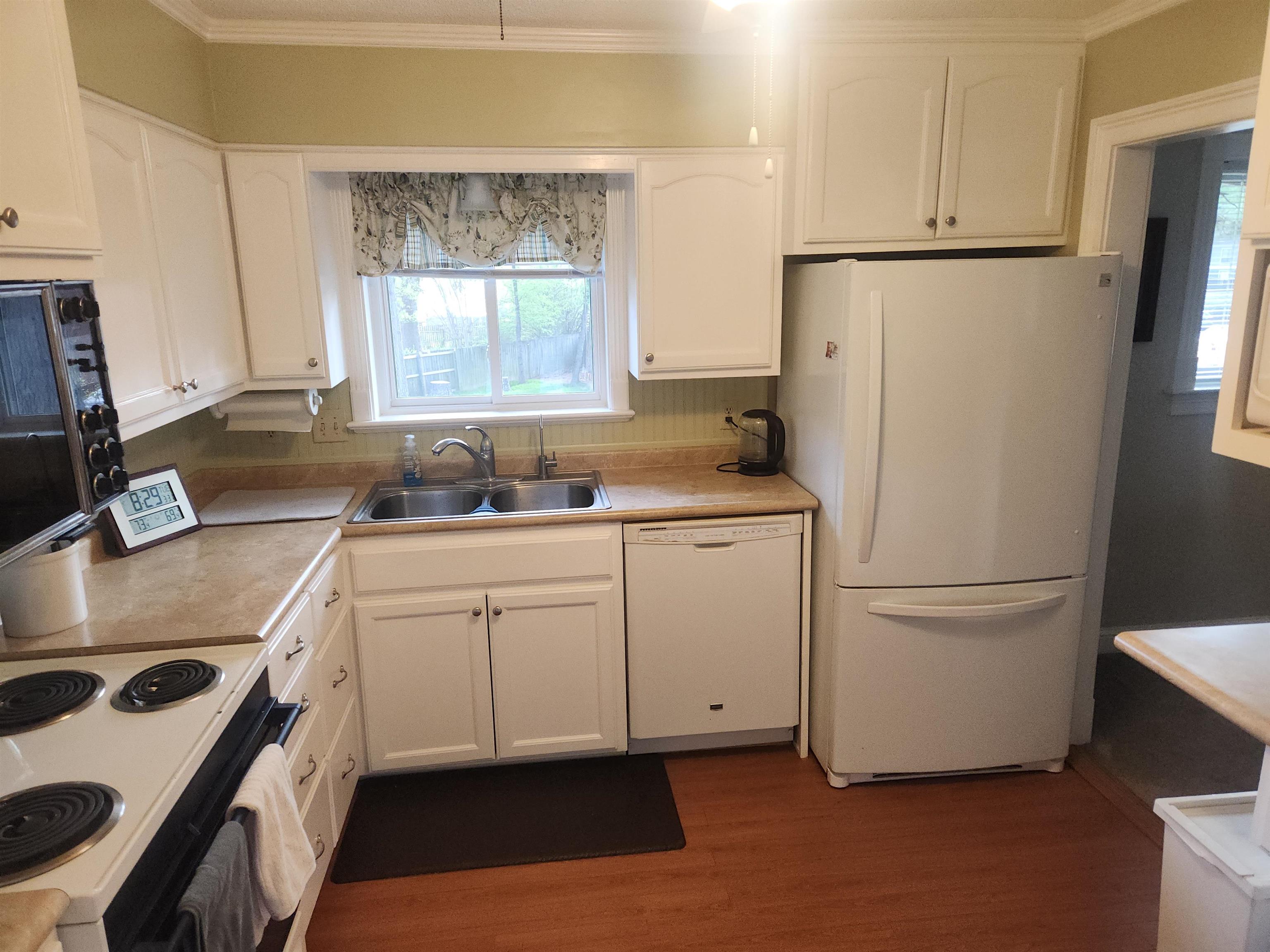 1424 Mullins Station Road Memphis, TN 38134 - Photo 9 of 40 a kitchen with white cabinets and white appliances