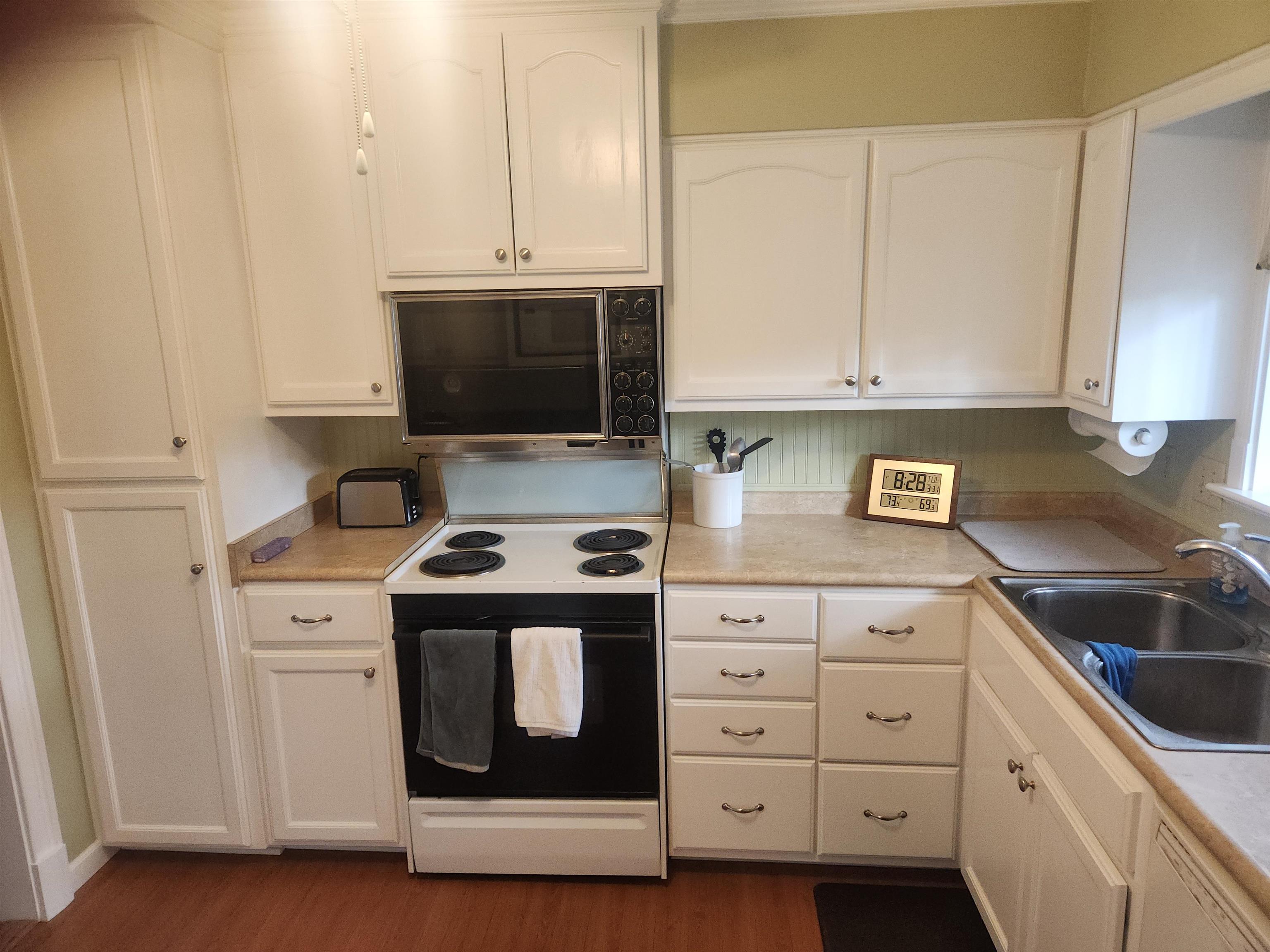 1424 Mullins Station Road Memphis, TN 38134 - Photo 10 of 40 a kitchen with white cabinets and a stove with a sink