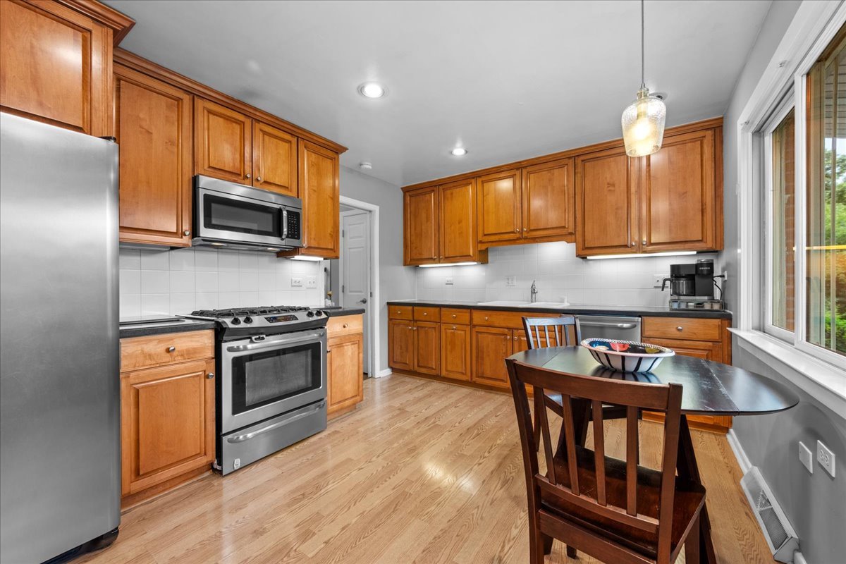 1115 Kenton Road Deerfield, IL 60015 - Photo 8 of 30 a kitchen with stainless steel appliances granite countertop a stove a sink a microwave and a refrigerator