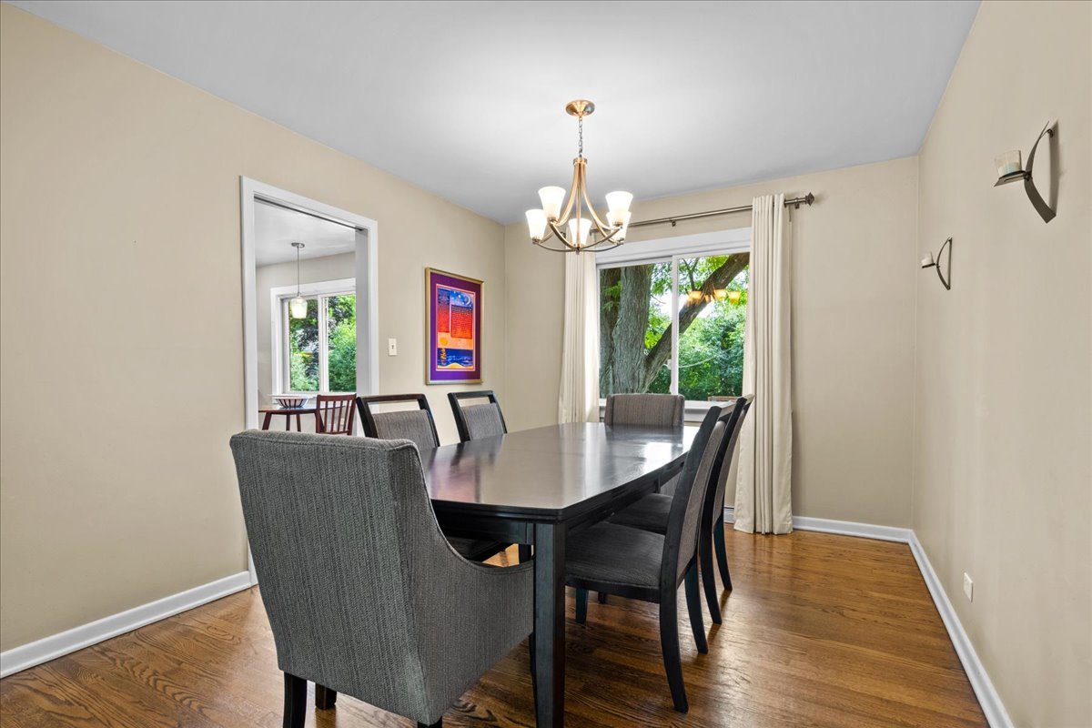 1115 Kenton Road Deerfield, IL 60015 - Photo 10 of 30 a view of a dining room with furniture a chandelier and wooden floor