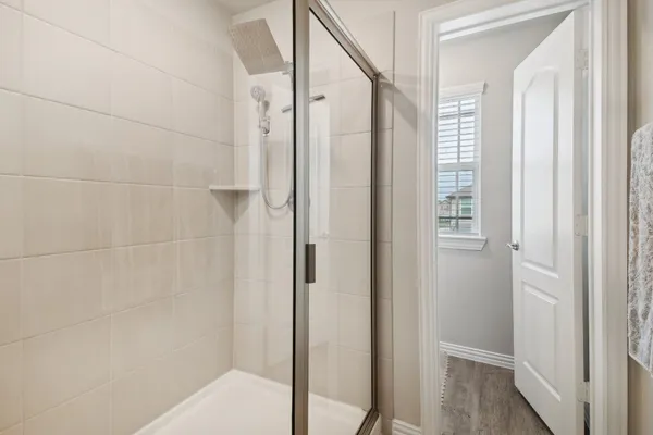 a bathroom with a shower and a glass door