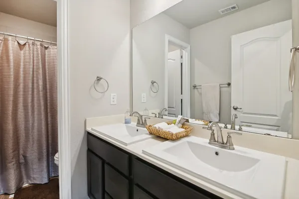 a bathroom with double sink and a mirror