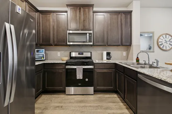 a kitchen with stainless steel appliances granite countertop a refrigerator stove and sink