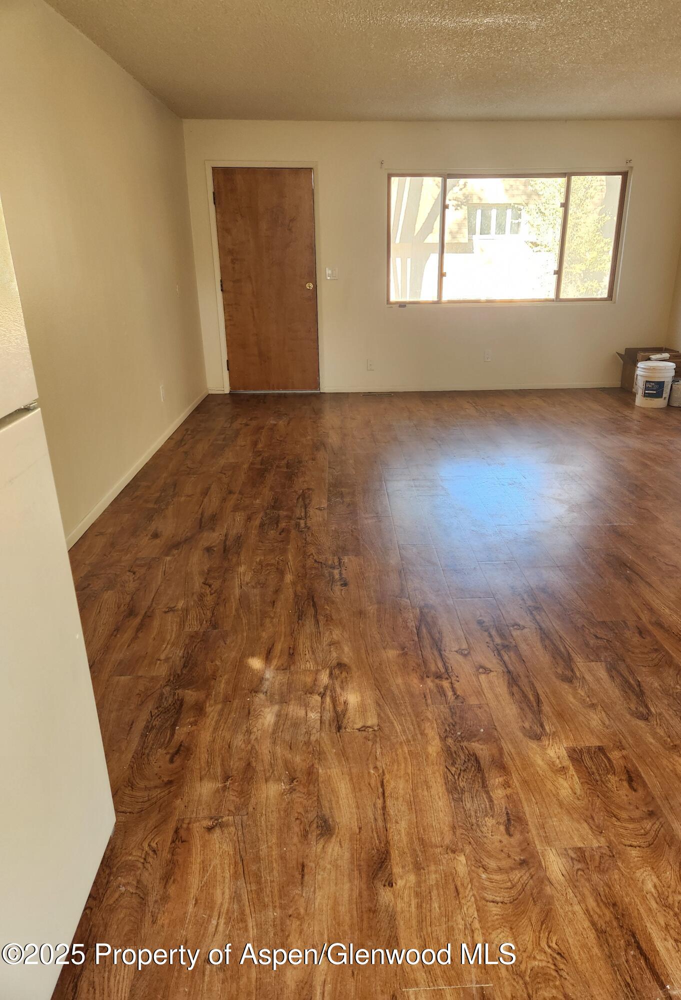 702 Midland Avenue Glenwood Springs, CO 81601 - Photo 2 of 7 an empty room with wooden floor and windows