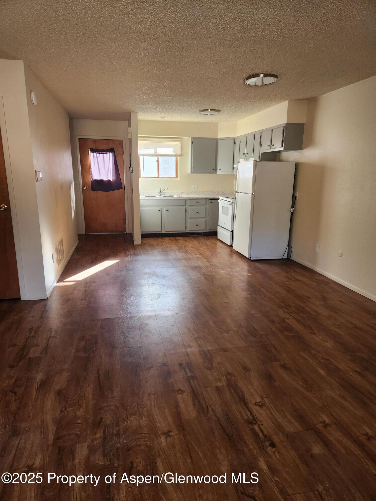 702 Midland Avenue Glenwood Springs, CO 81601 - Photo 3 of 7 a view of empty room with wooden floor and fan