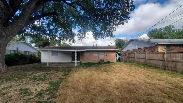 a view of a house with a large tree and a yard