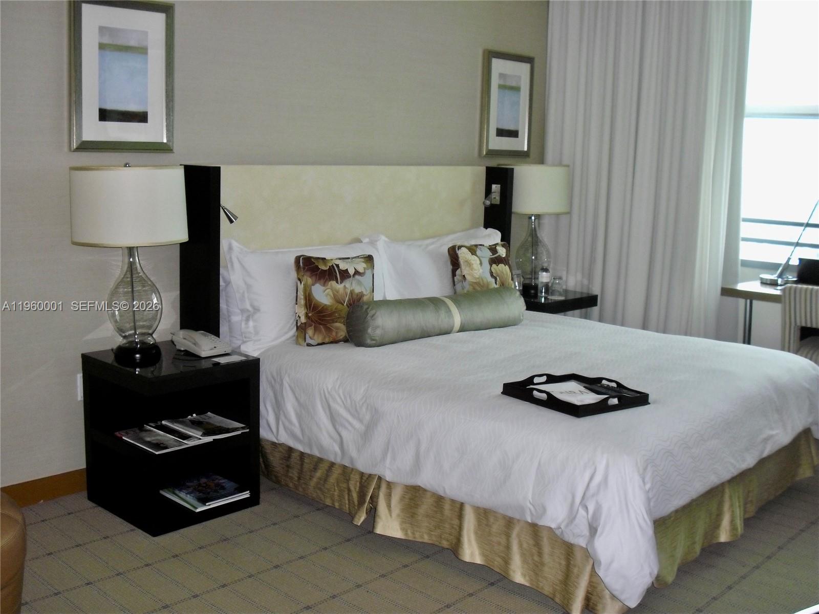 1395 Brickell Avenue, Unit 3210 Miami, FL 33131 - Photo 2 of 10 a bedroom with a bed and a lamp