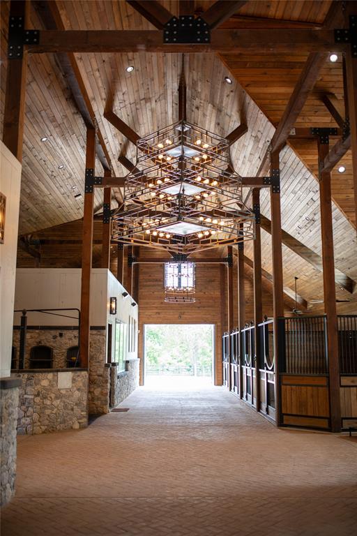 5000 T W King Road Southlake, TX 76092 - Photo 9 of 40 Chandeliers hang from the vaulted barn ceiling, adding sophistication to equestrian luxury.