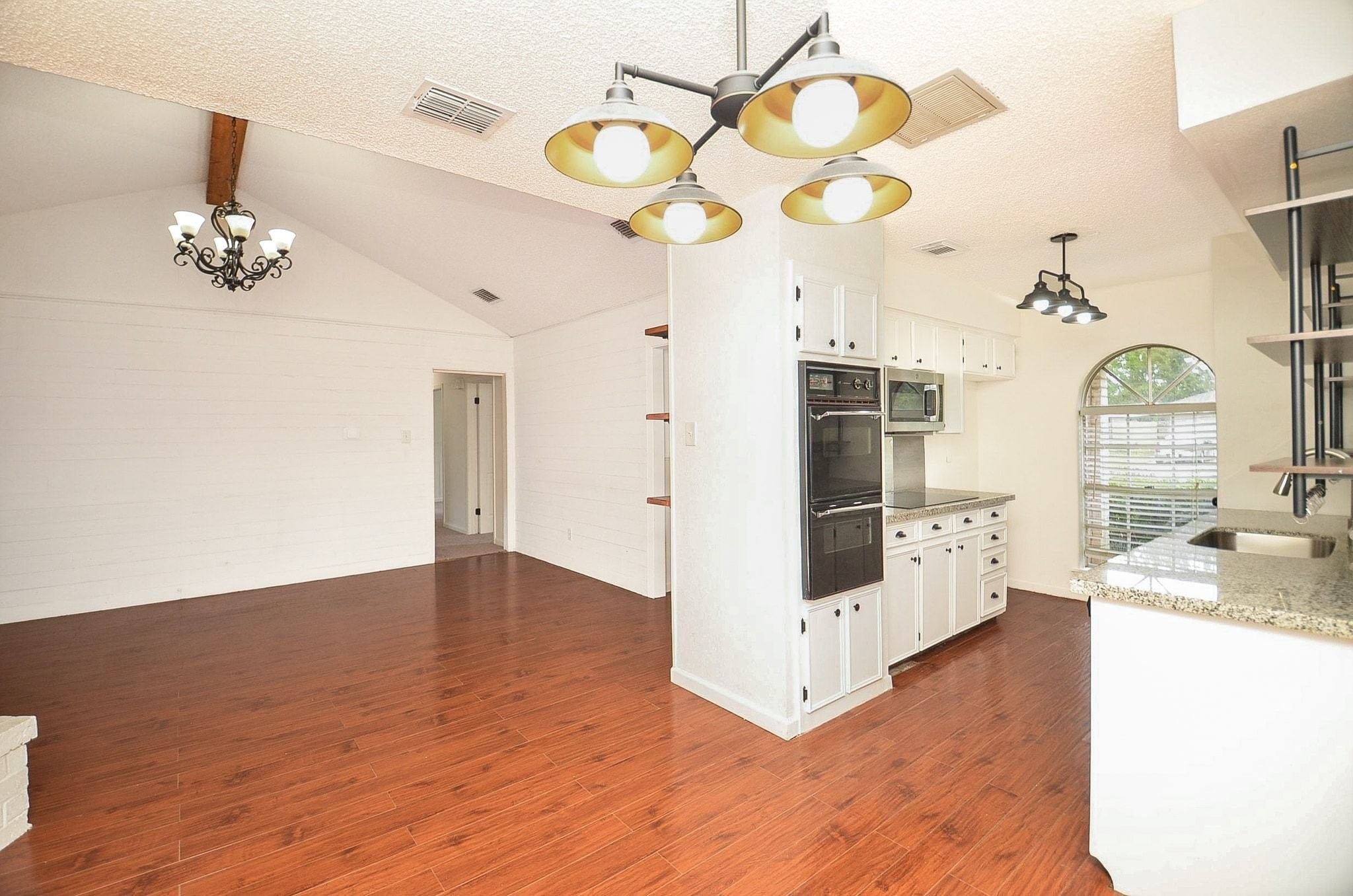 9014 Langfield Road Houston, TX 77040 - Photo 12 of 37 Seamlessly connected to the kitchen, this sunlit space features rich wood-look flooring and clean white shiplap accent walls for a modern, inviting touch. Dedicated alcove design ideal for everyday family meals or intimate gatherings.