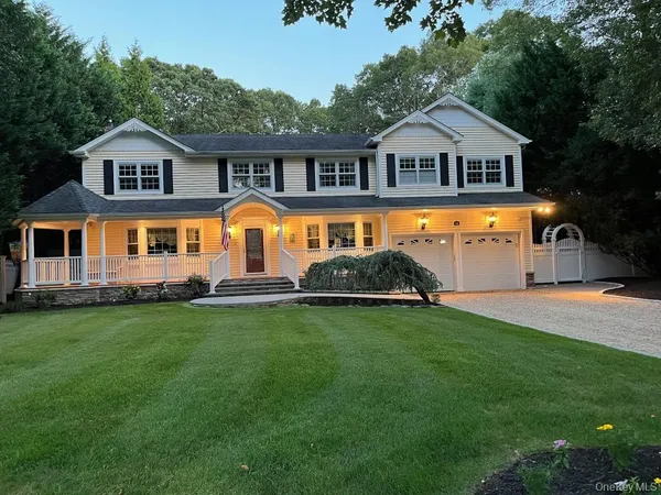 a front view of a house with a yard and trees