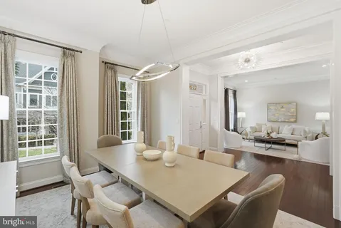 a view of a dining room and livingroom with furniture wooden floor a chandelier
