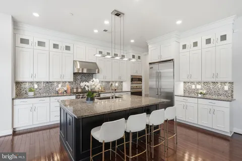 a kitchen with refrigerator cabinets dining table and chairs