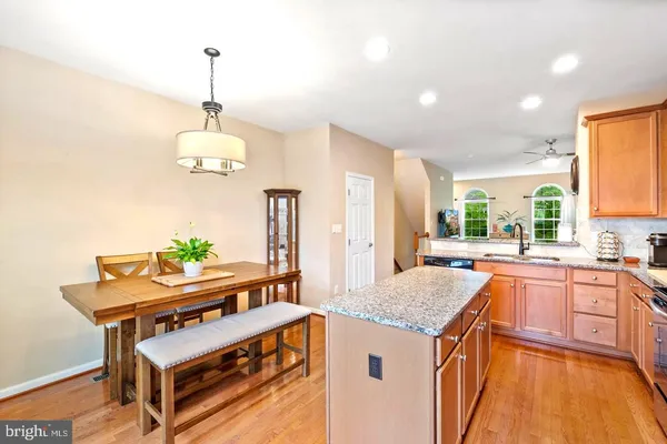 a kitchen with stainless steel appliances granite countertop a sink and a wooden floor