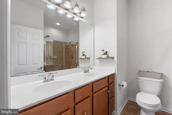 a bathroom with a sink a toilet and a large mirror