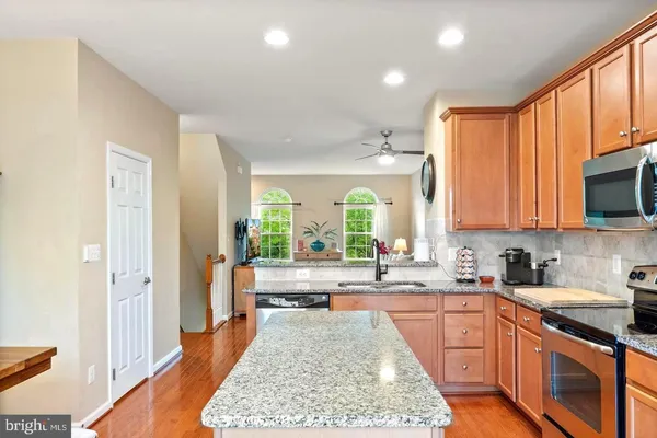 a large kitchen with kitchen island granite countertop a large window