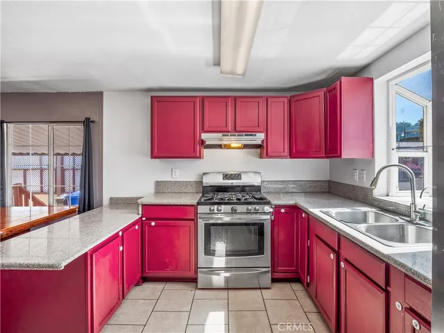 a kitchen with stainless steel appliances granite countertop a refrigerator stove top oven and sink