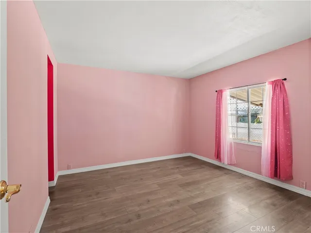 an empty room with wooden floor and bathroom