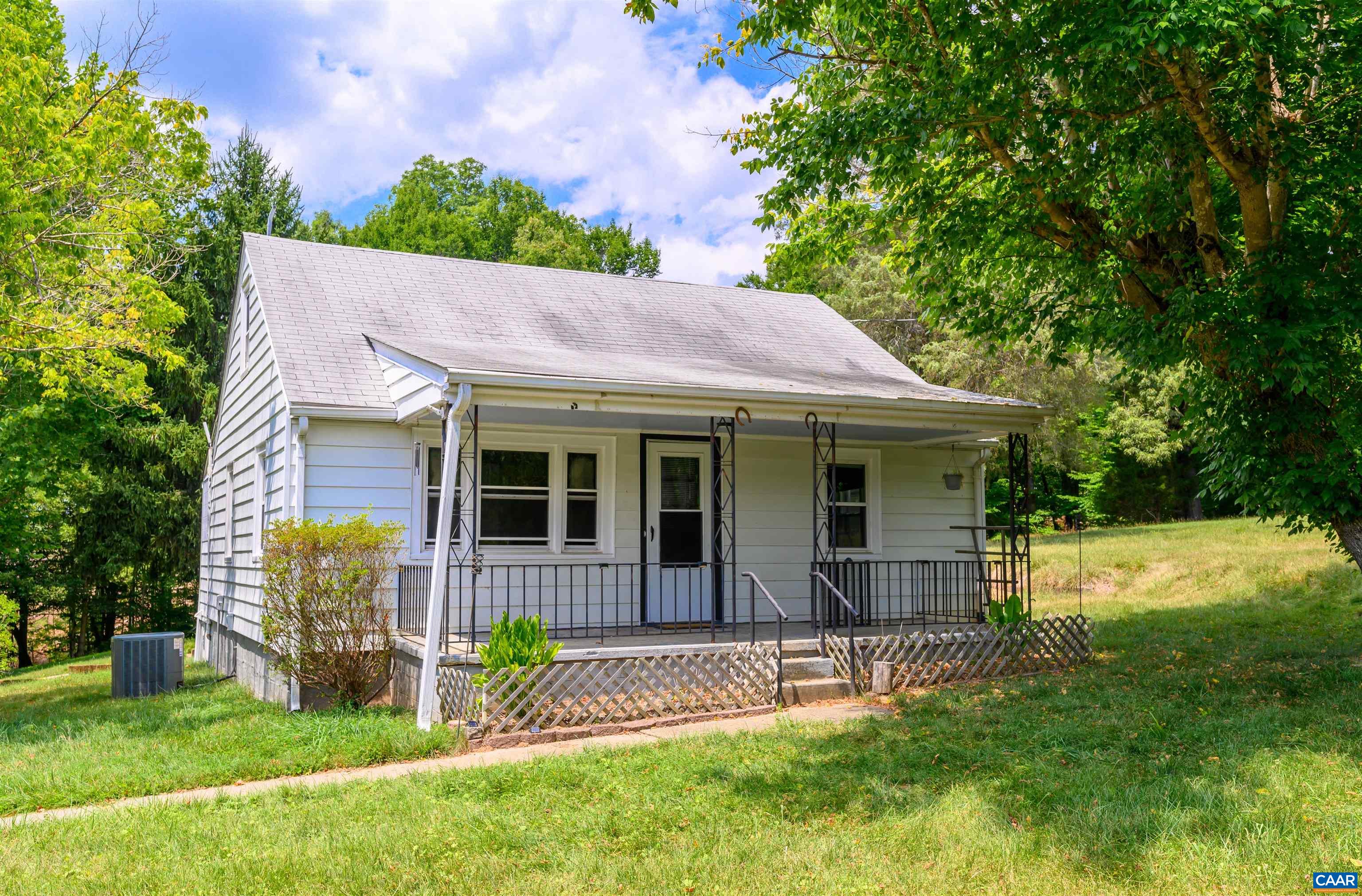 a view of a house with backyard and a tree