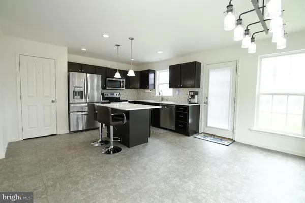 a kitchen with stainless steel appliances granite countertop a sink refrigerator and cabinets