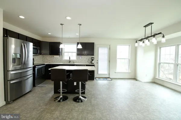 a large kitchen with a large counter top appliances and cabinets
