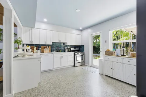a kitchen with granite countertop white cabinets and white appliances