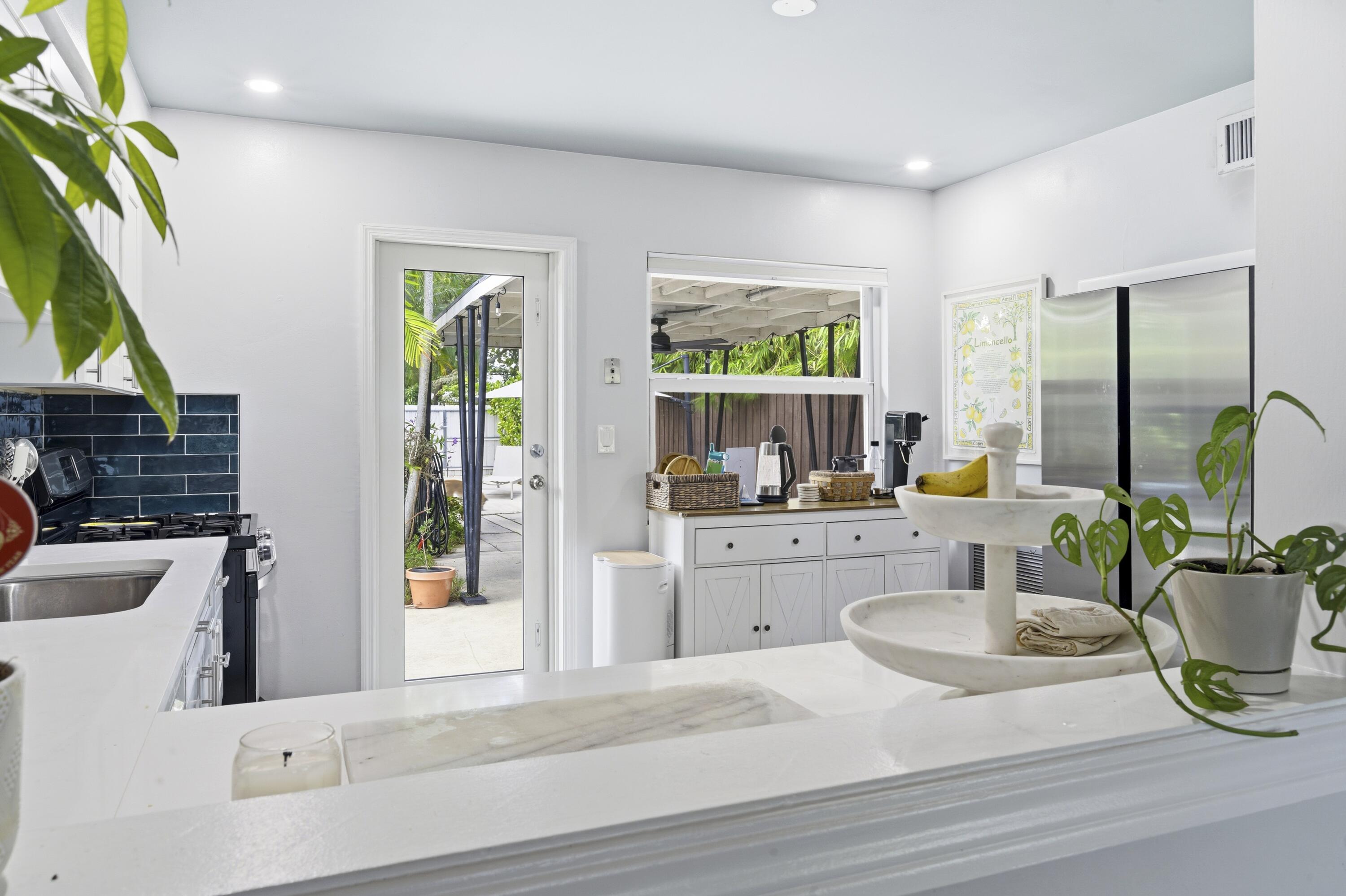 1119 North M Street Lake Worth Beach, FL 33460 - Photo 12 of 26 a kitchen with a stove a sink and a dining table with garden view
