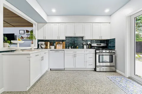 a kitchen with white cabinets and white appliances