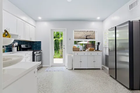 a kitchen with white cabinets and appliances
