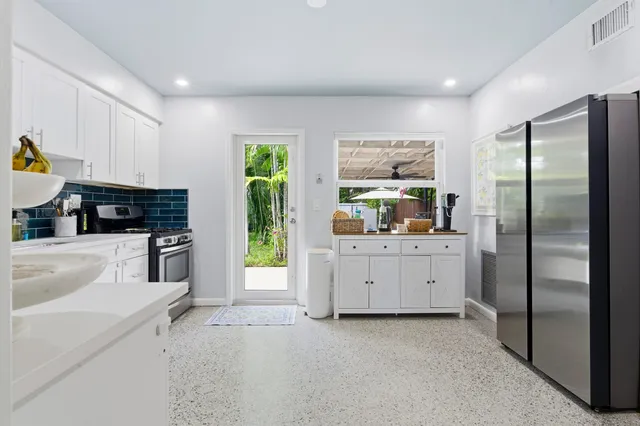 a kitchen with white cabinets and appliances