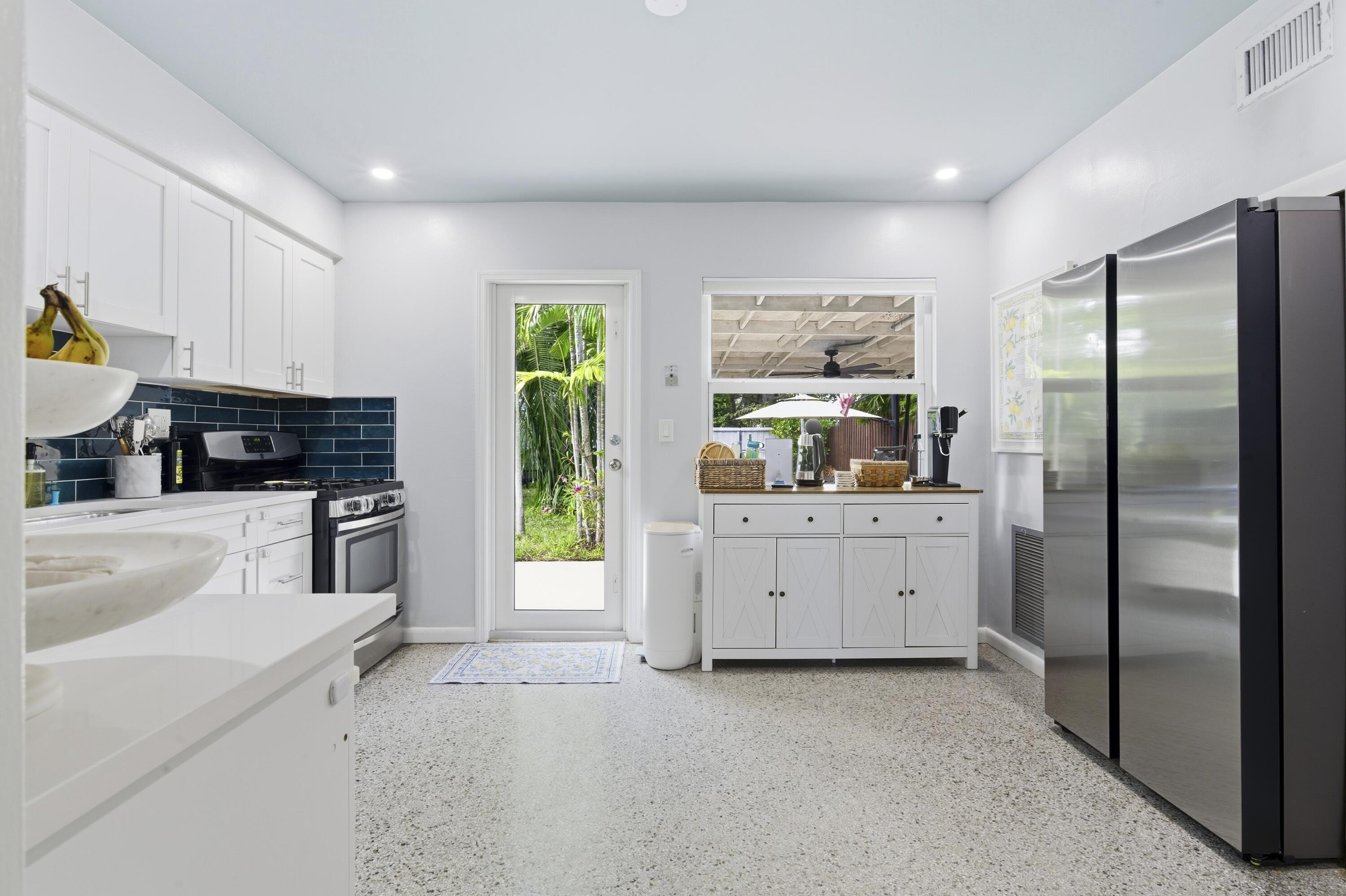 1119 North M Street Lake Worth Beach, FL 33460 - Photo 14 of 26 a kitchen with white cabinets and appliances