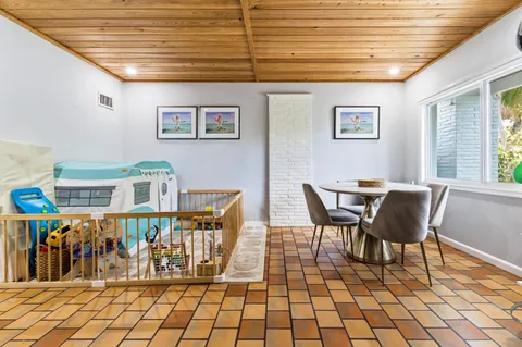 a dining room with furniture and next to a window