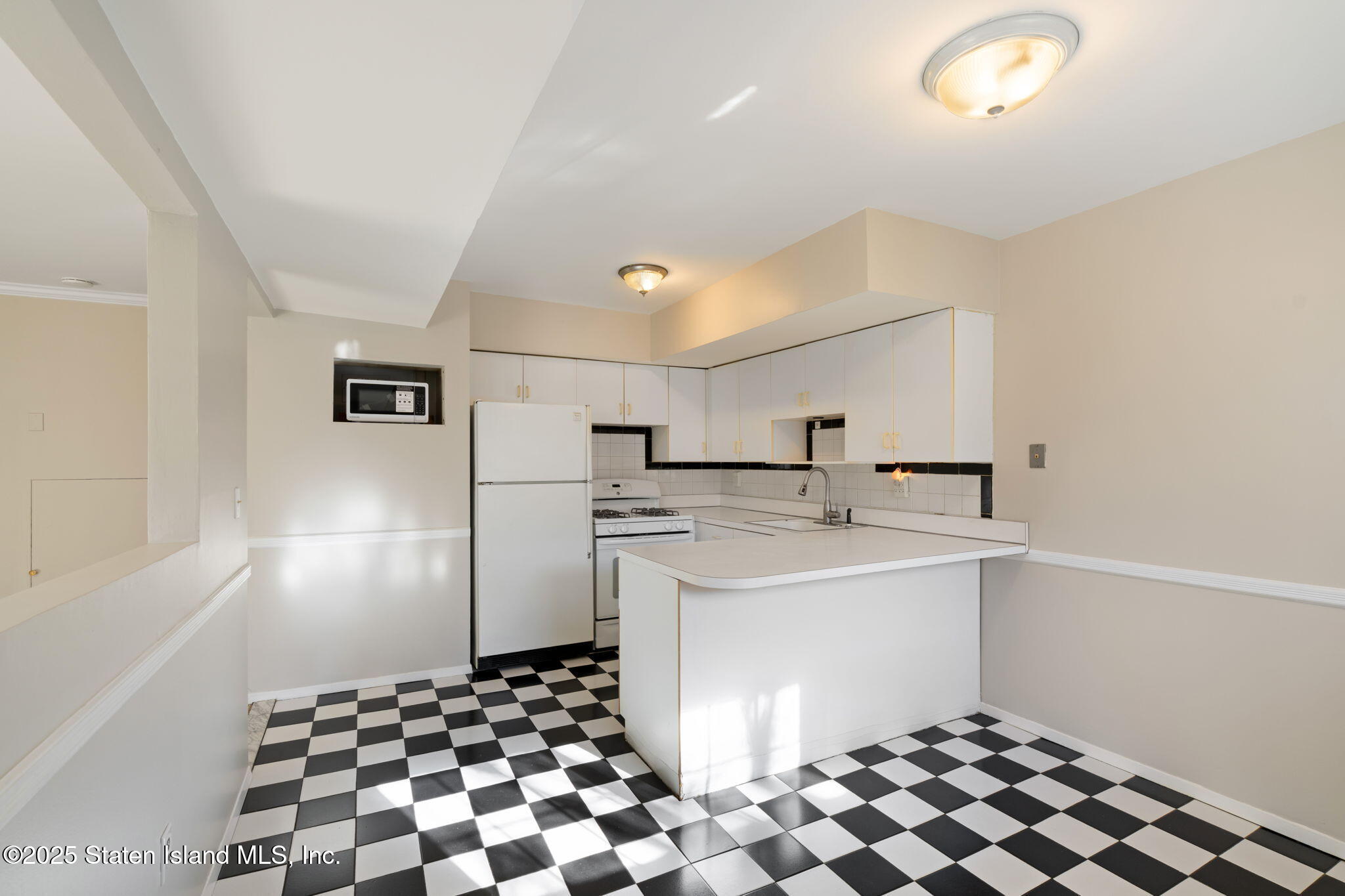 8 Dreyer Avenue, Unit A Staten Island, NY 10314 - Photo 4 of 23 a kitchen with a sink a refrigerator and cabinets